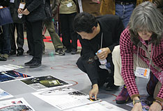 2次審査 選んだ4作品に付箋を貼っていく。左から石田敏明氏、クライン氏