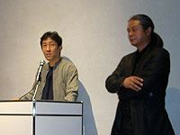 審査現場を統括する小泉氏（左）。右は司会の橋本氏。