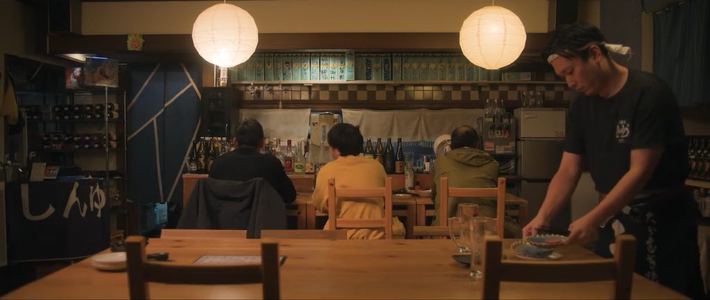 東京の昔ながらの居酒屋にて、男性3人が飲食しているシーン